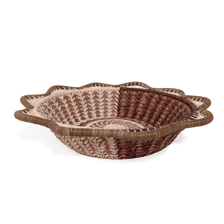 Handmade woven basket with decorative pattern on a white background