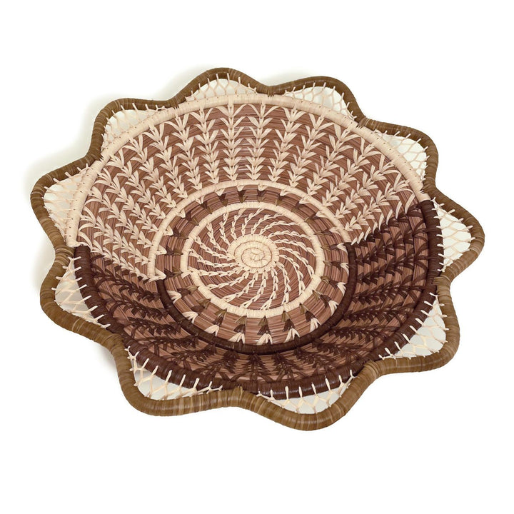 Decorative woven basket with a spiral pattern on a white background