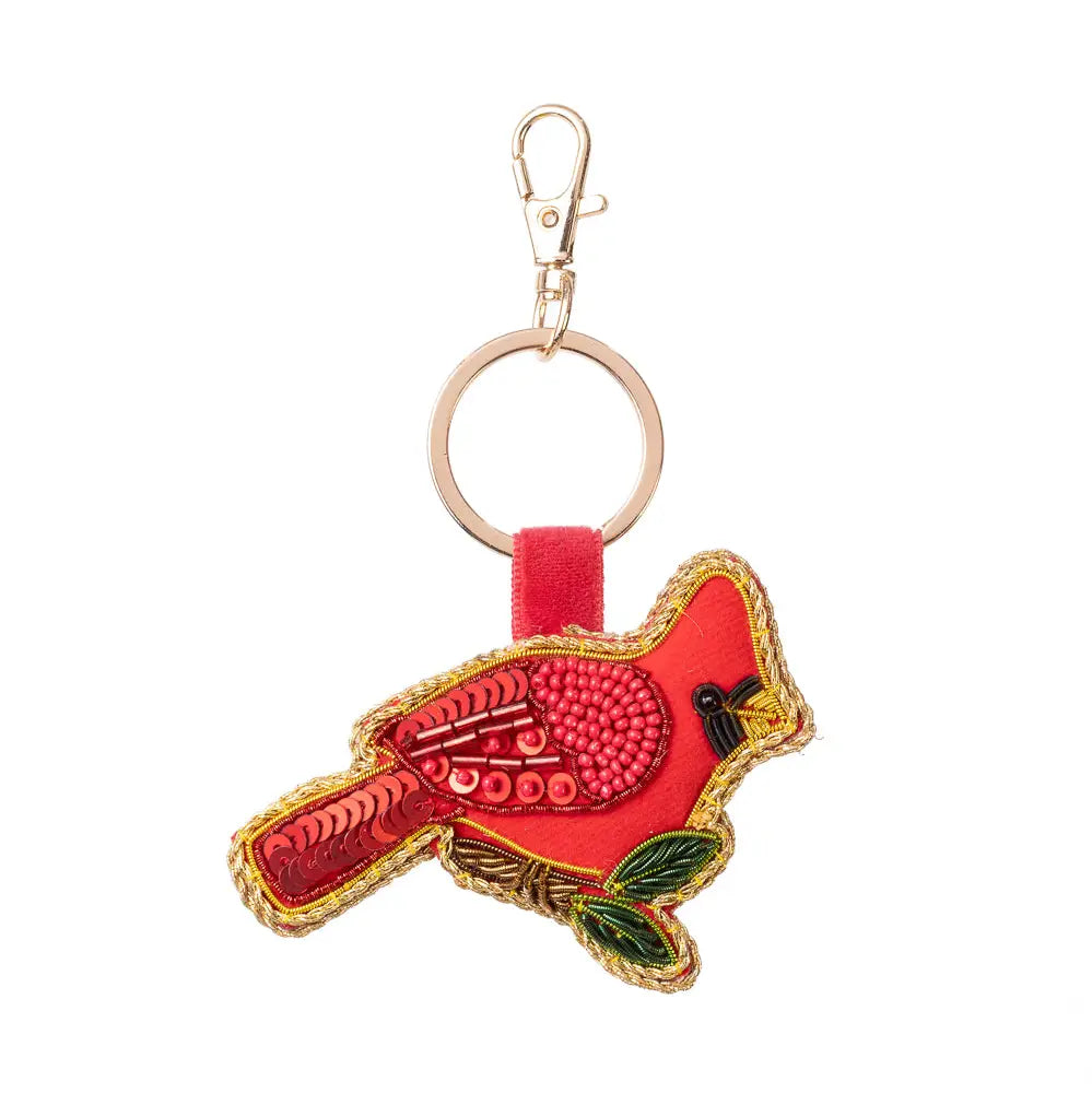 A red cardinal-shaped embroidered keychain charm with a gold-tone metal clasp and key ring, featuring green leaves and a black beak detail, on a plain white background.