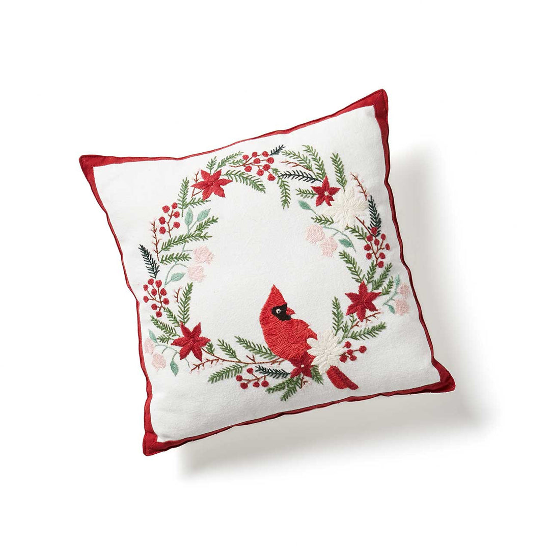 Decorative pillow with a red cardinal and floral design on a white background