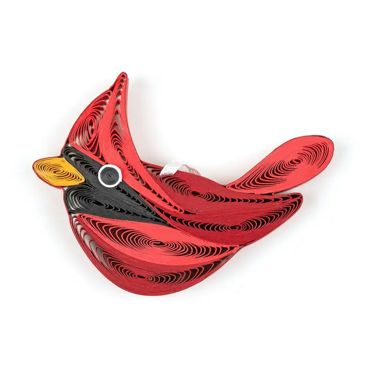A quilled paper cardinal ornament featuring a red body, black neck, yellow beak, and white eye, photographed on a clean white background.