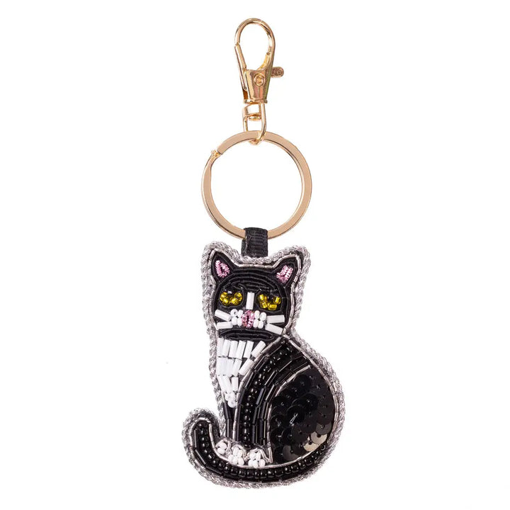A black cat-shaped keychain charm with embroidered details, yellow eyes, and a gold-tone clasp on a plain white background.