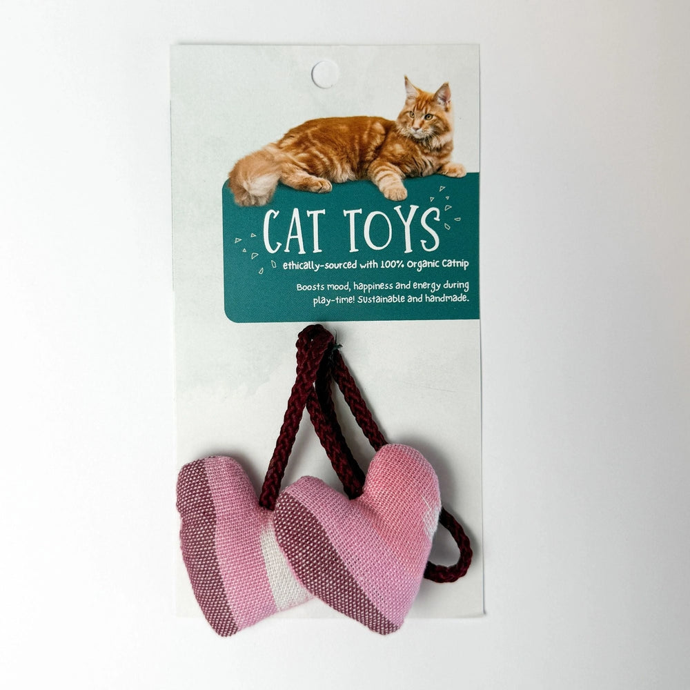 Cat toys with pink hearts and brown rope on a white card with a cat illustration and text.