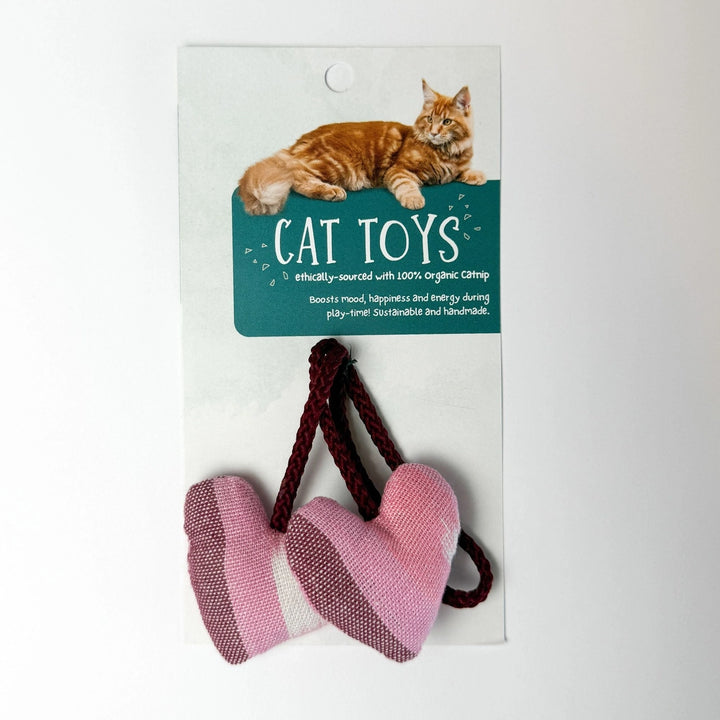 Cat toys with pink hearts and brown rope on a white card with a cat illustration and text.