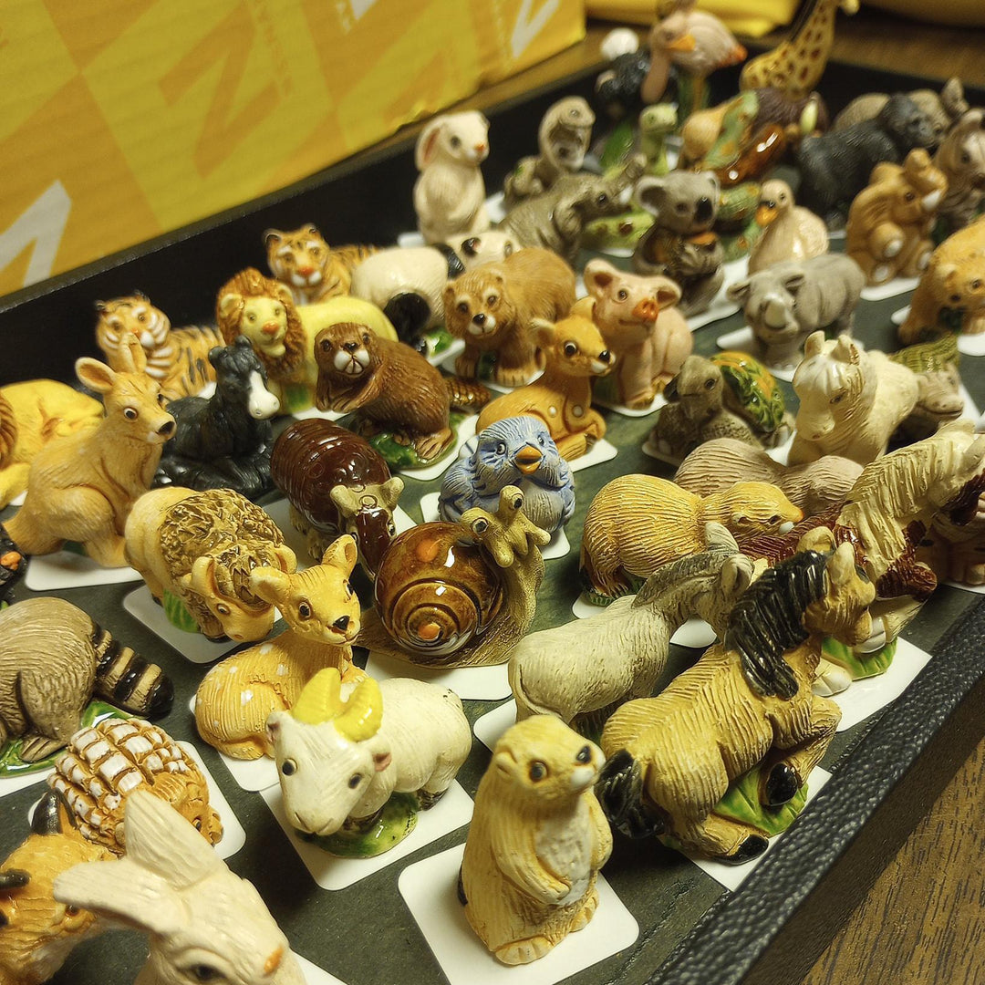 Collection of small animal figurines on a display stand.
