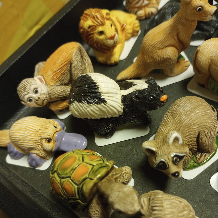 Collection of small animal figurines on a dark surface