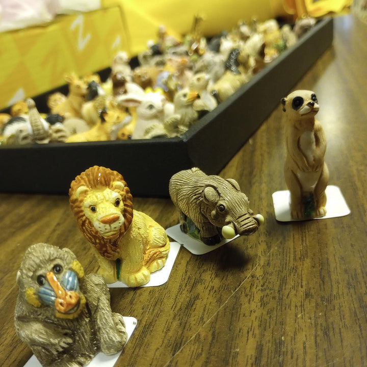 Collection of animal figurines on a wooden surface with a blurred background
