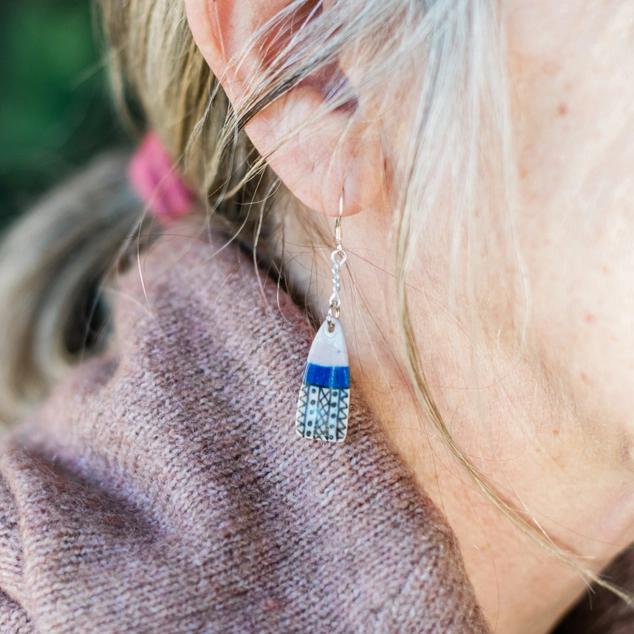 Painted ceramic dangle earring on a woman model