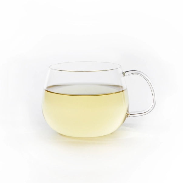 Clear glass mug filled with Chamomile Dream tea on a white background