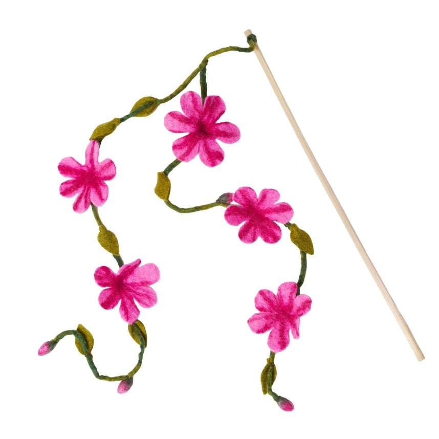 A decorative cat teaser with five bright pink flowers and green stems on a thin wooden stick, shown against a plain white background.