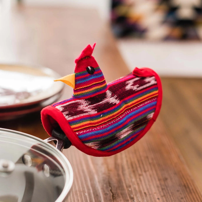 Colorful oven mitt shaped like a bird on a wooden surface