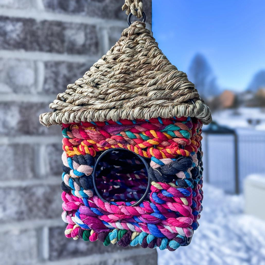 Colorful hanging bird cottage with a woven roof and walls. 