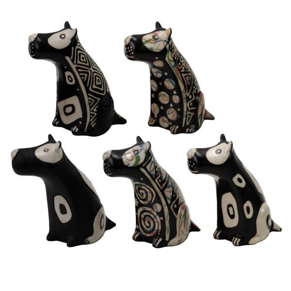Five black and white ceramic dog figurines with tribal patterns on a white background