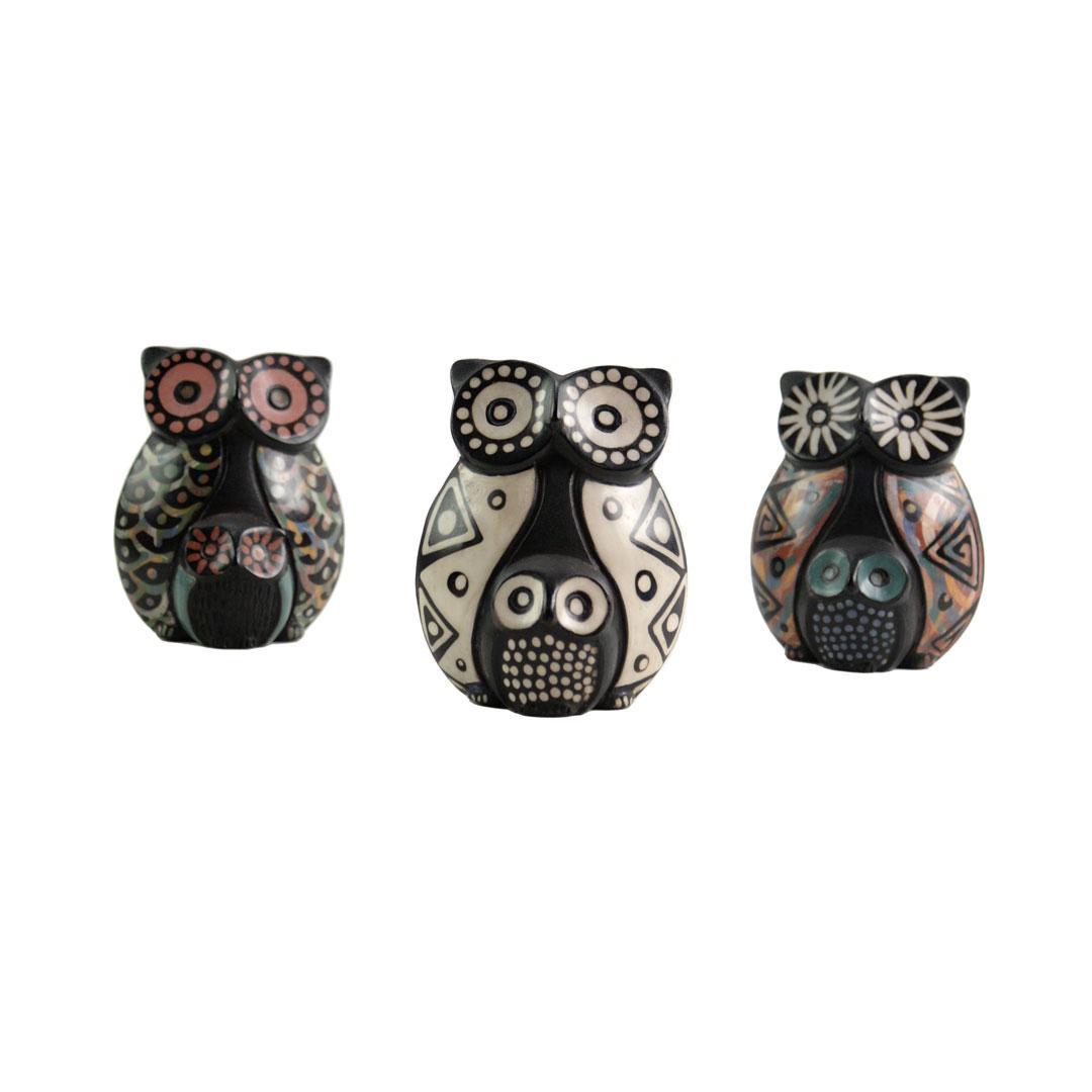 Three decorative owl figurines with patterned designs on a white background