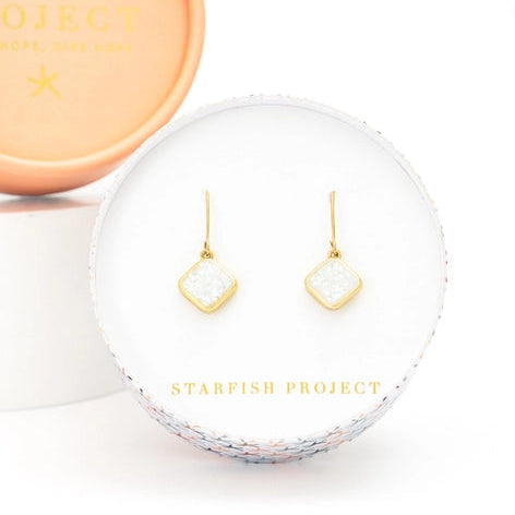 Gold square earrings in a clear display case with 'Starfish Project' branding.