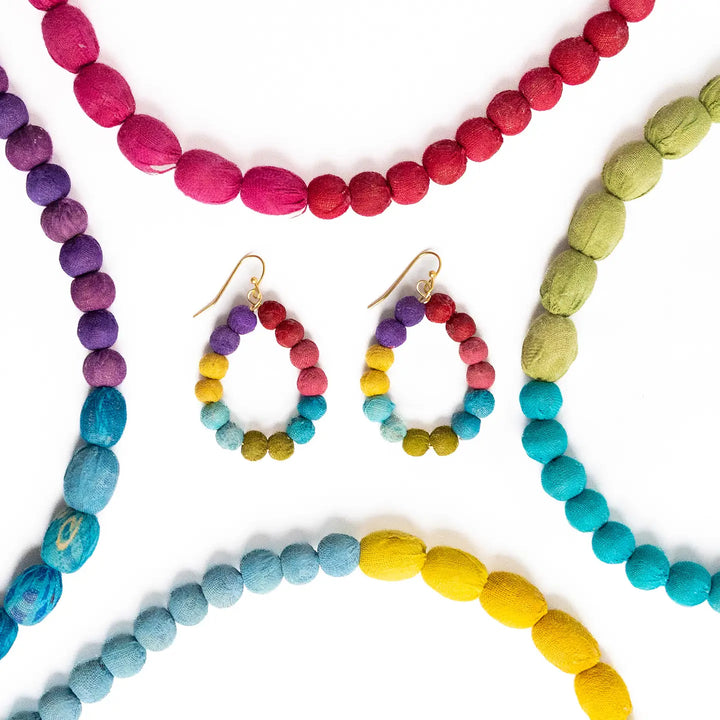 Colorful beaded Kantha jewelry including necklaces and earrings on a white background