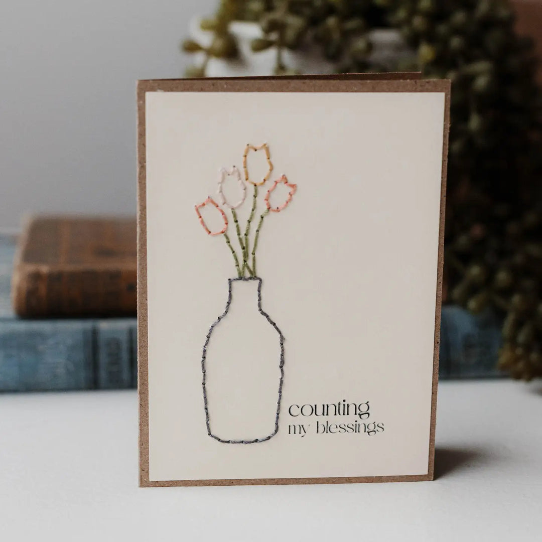 A greeting card that says Counting my Blessing with a vase with tulips