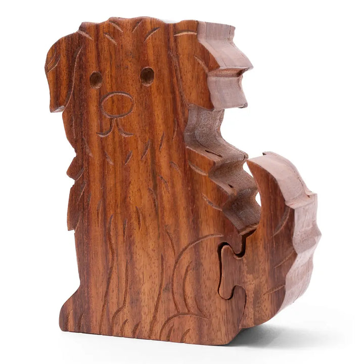 A carved wooden dog-shaped puzzle piece with a warm brown wood grain finish, shown on a clean white background.