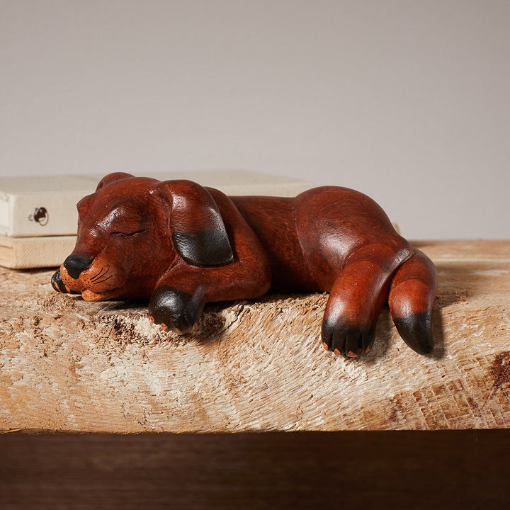 Wooden dog figurine on a wooden surface with a neutral background