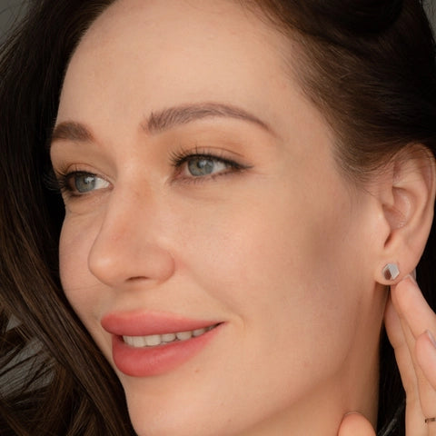 Close-up of a woman wearing earrings with a focus on the jewelry.