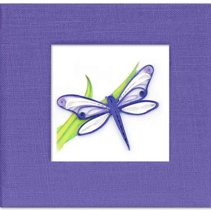 Blue dragonfly sticky note on a white background, framed by purple fabric.