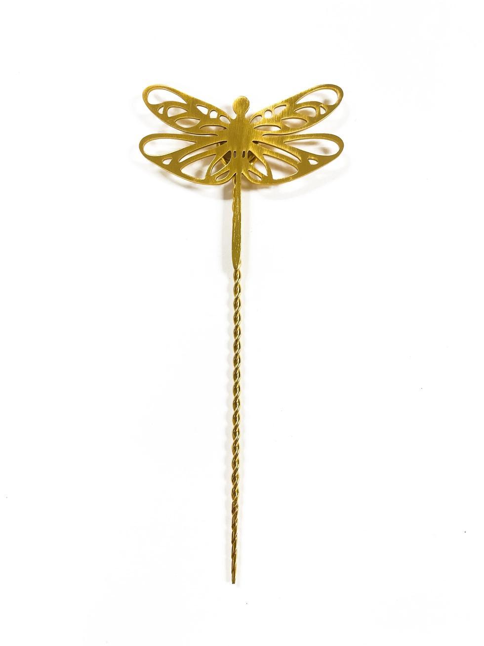Gold dragonfly-shaped plant stake on a white background