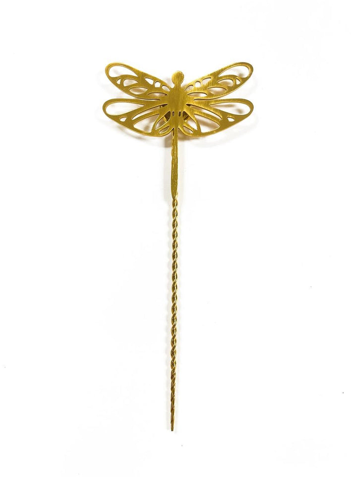 Gold dragonfly-shaped plant stake on a white background
