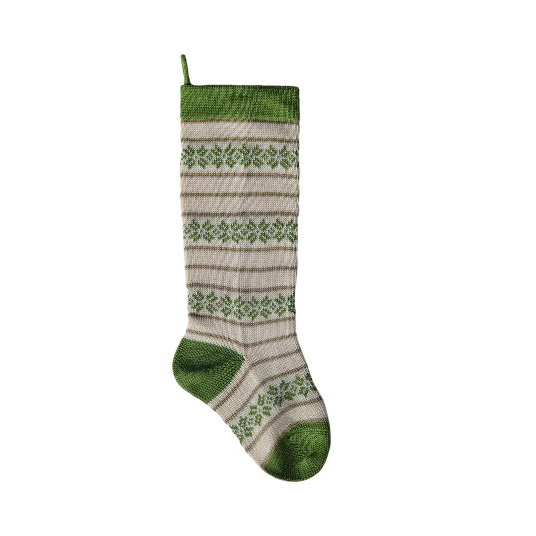 A knit Christmas stocking with a green and beige pattern, featuring horizontal stripes and snowflake motifs, with a green hanging loop at the top.
