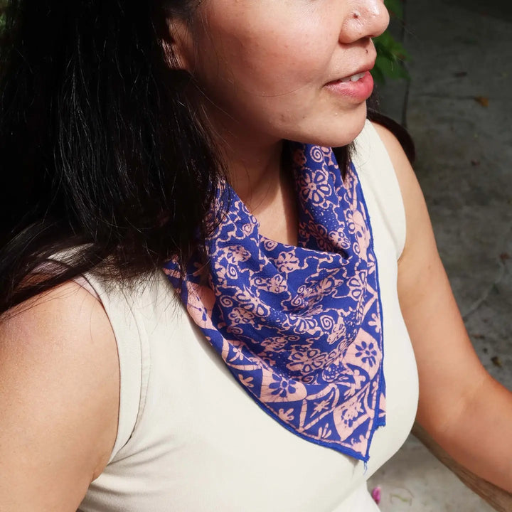 Woman wearing a blue patterned scarf on her neck