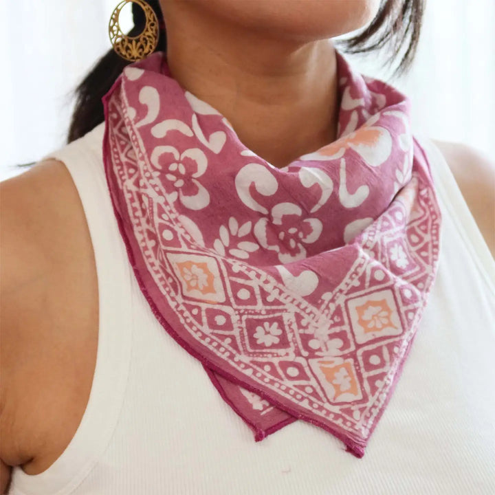 Person wearing a pink patterned scarf with a white background