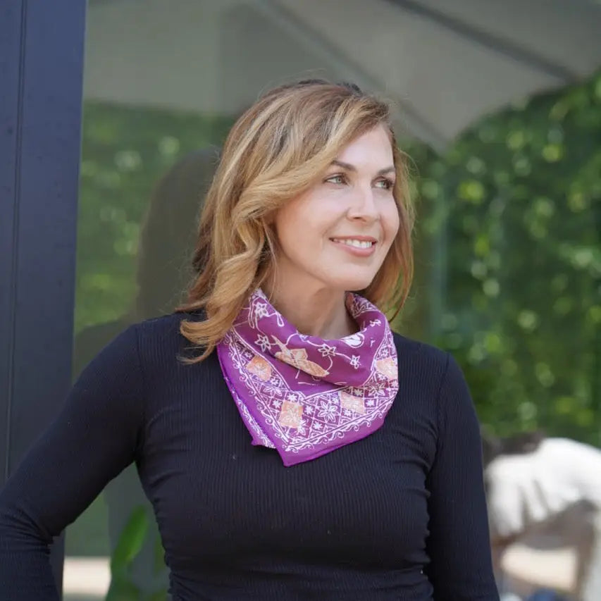 Woman wearing a purple bandana with a floral pattern outdoors