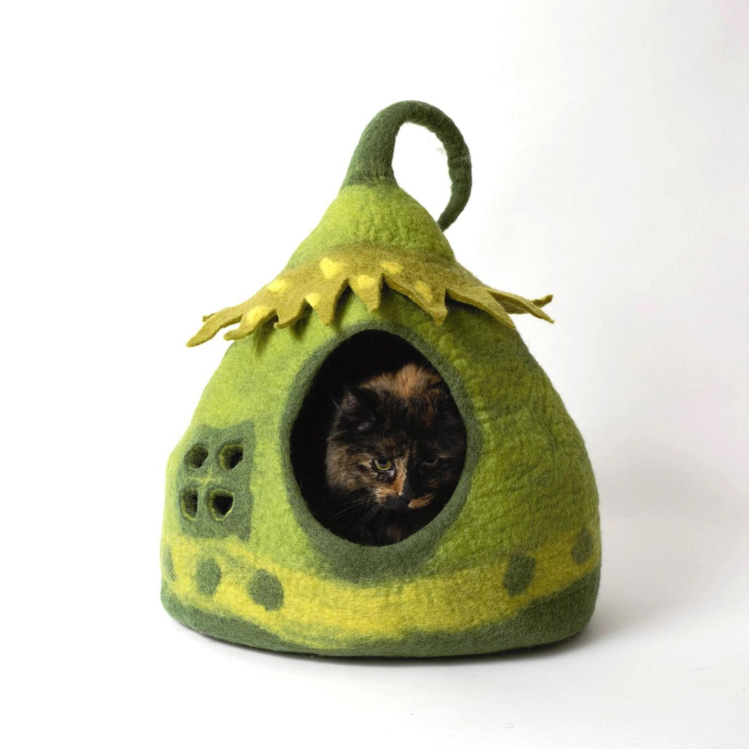 Green felted fairy pet house with a cat peeking out on a white background
