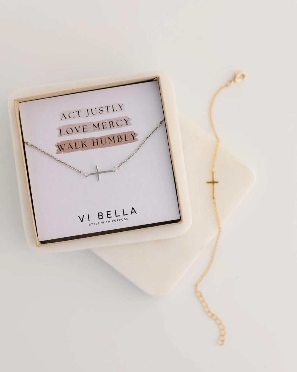 Cross bracelet with motivational message card in a box on a light background