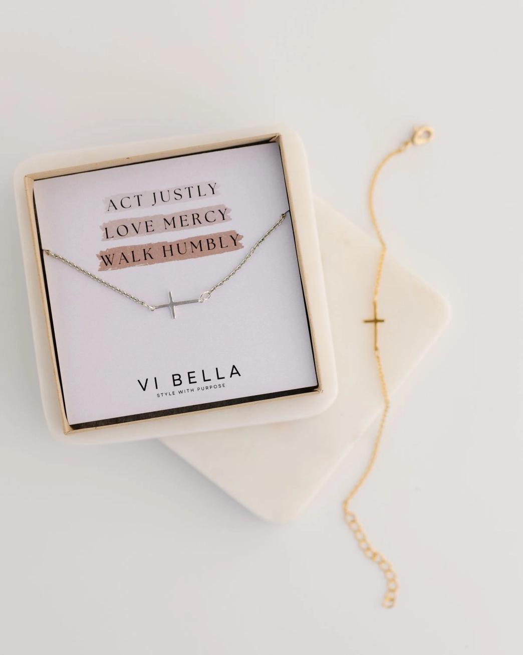 Cross bracelet with motivational message card in a box on a light background