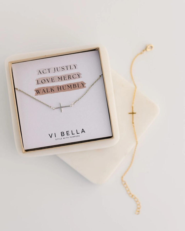 Cross bracelet with motivational message card in a box on a light background