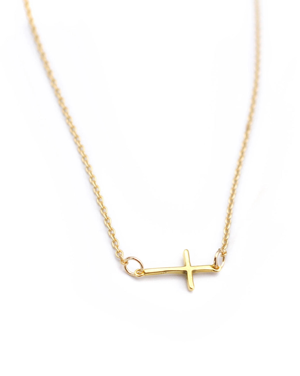 Gold necklace with a cross pendant on a white background