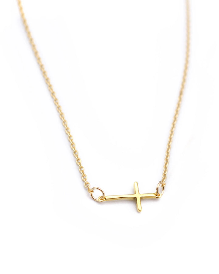 Gold necklace with a cross pendant on a white background