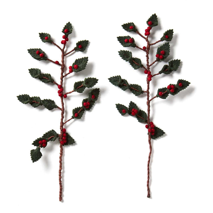 Two decorative holly branches with red berries on a white background