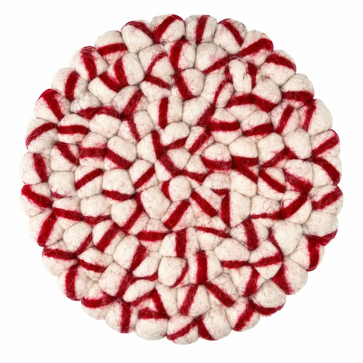 A round felted wool trivet with a red and off-white striped pattern, photographed from directly above on a solid white background.
