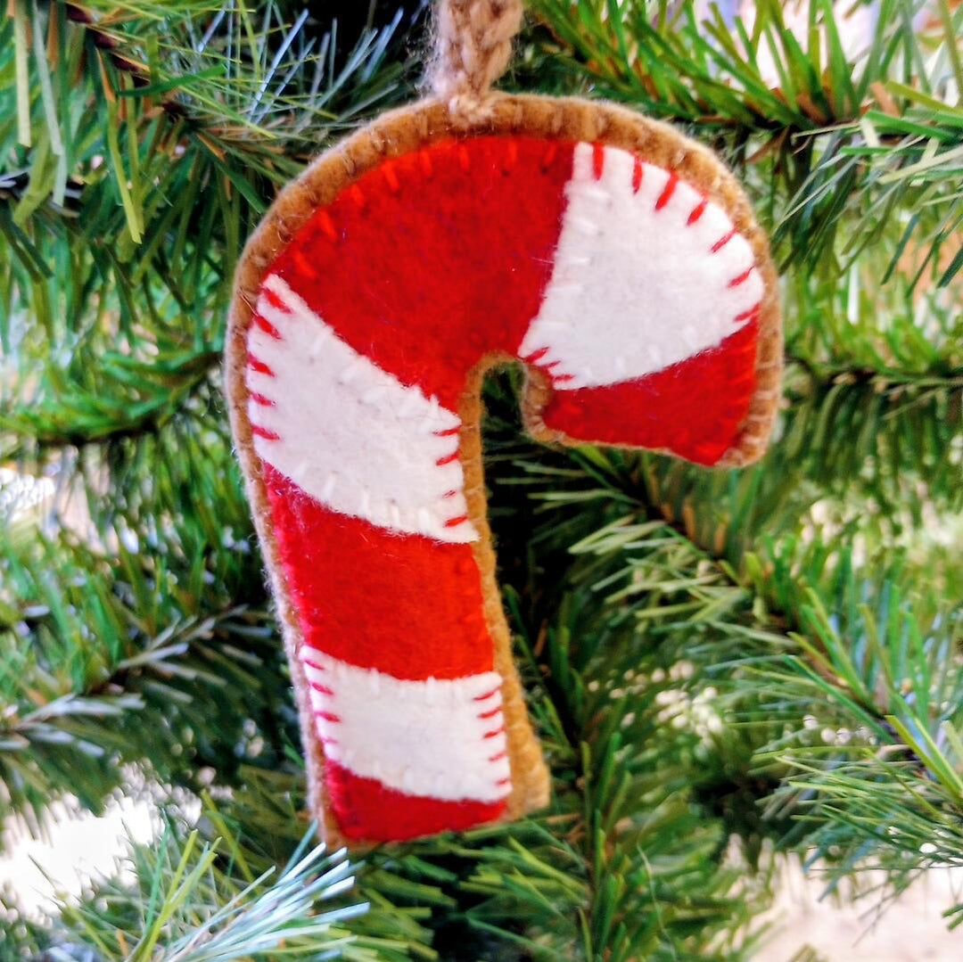 Felt candy cane ornament hanging on a Christmas tree