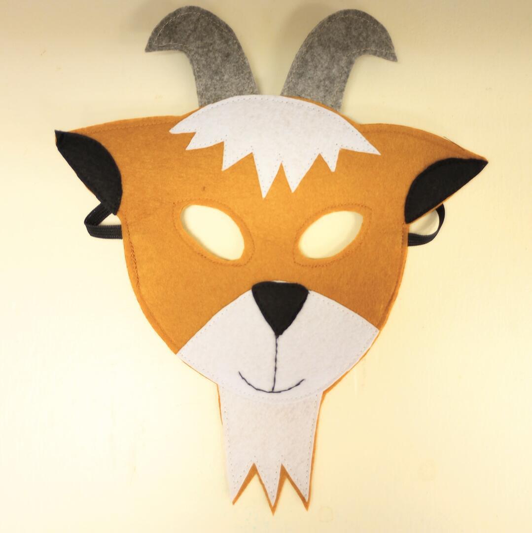 Felt animal mask with goat design on a beige background