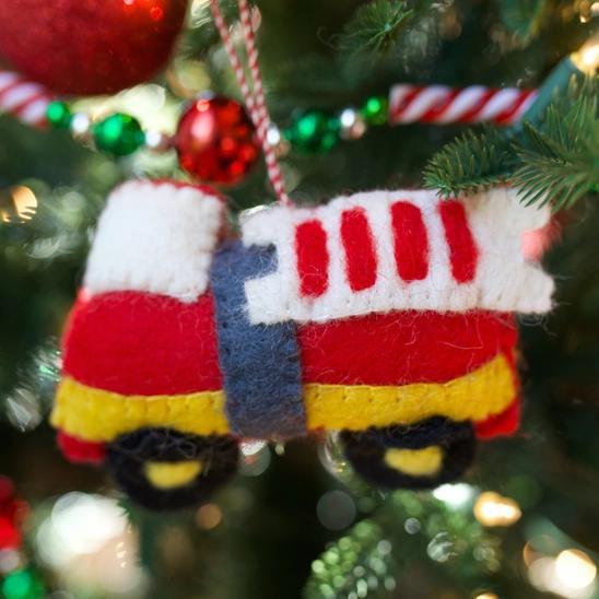 Handmade felt ornament in vehicle shape of red firetruck.