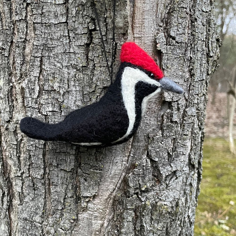Felted woodenpecker ornament on a tree trunk