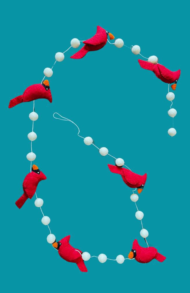 Decorative garland with red cardinal birds and white beads on a teal background