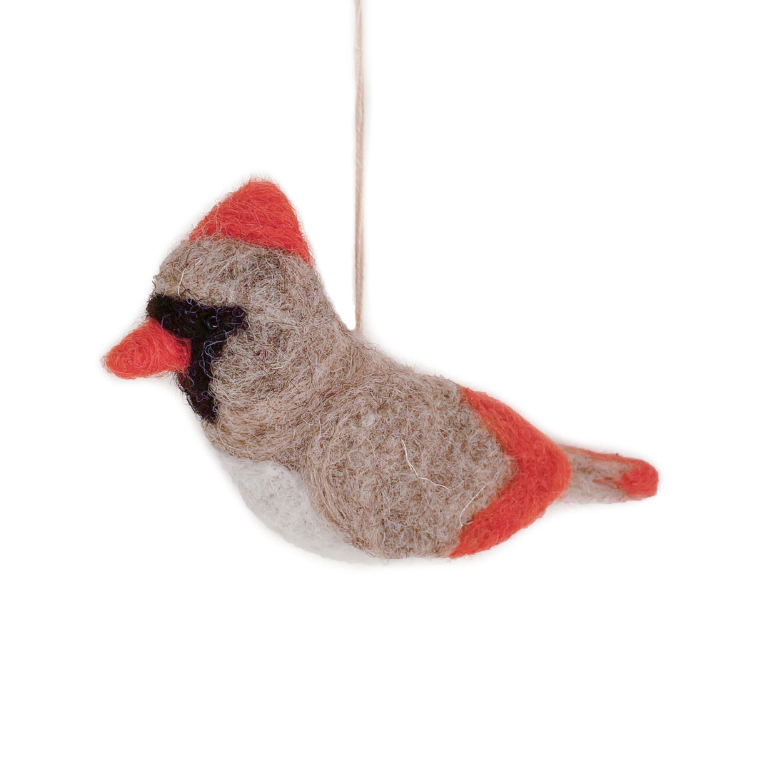 A felted wool cardinal bird ornament hanging from a thin string against a solid white background.