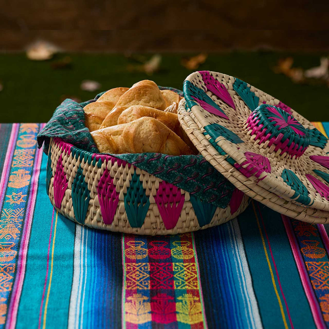 Woven basket with colorful lid on a patterned fabric background