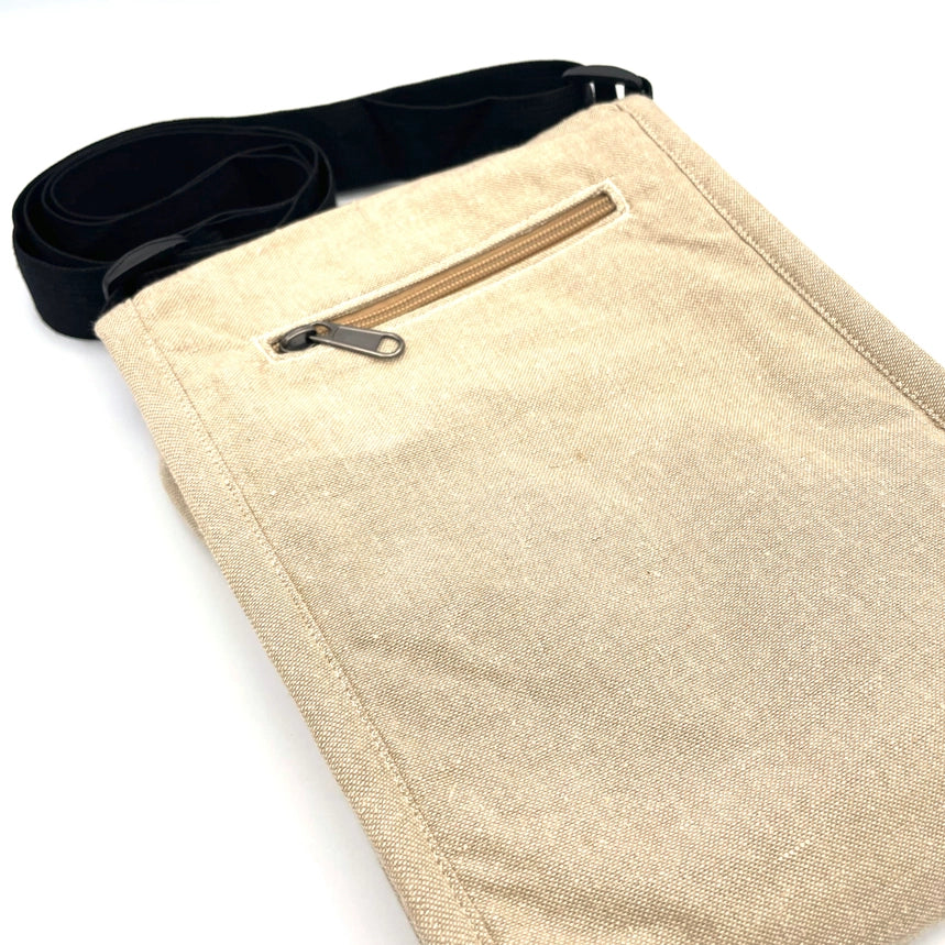 Beige apron with a zipper pocket and black strap on a white background