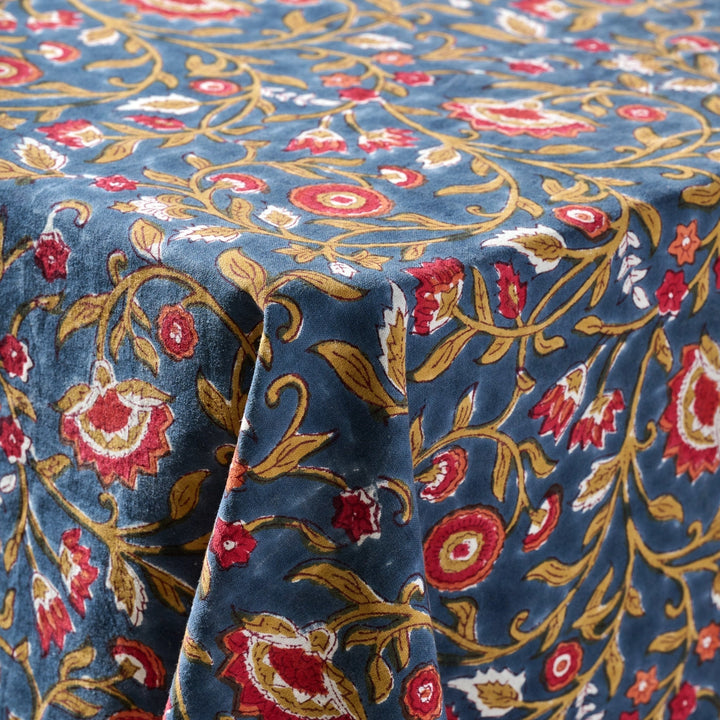 Floral patterned fabric with red, gold, and white flowers on a blue background