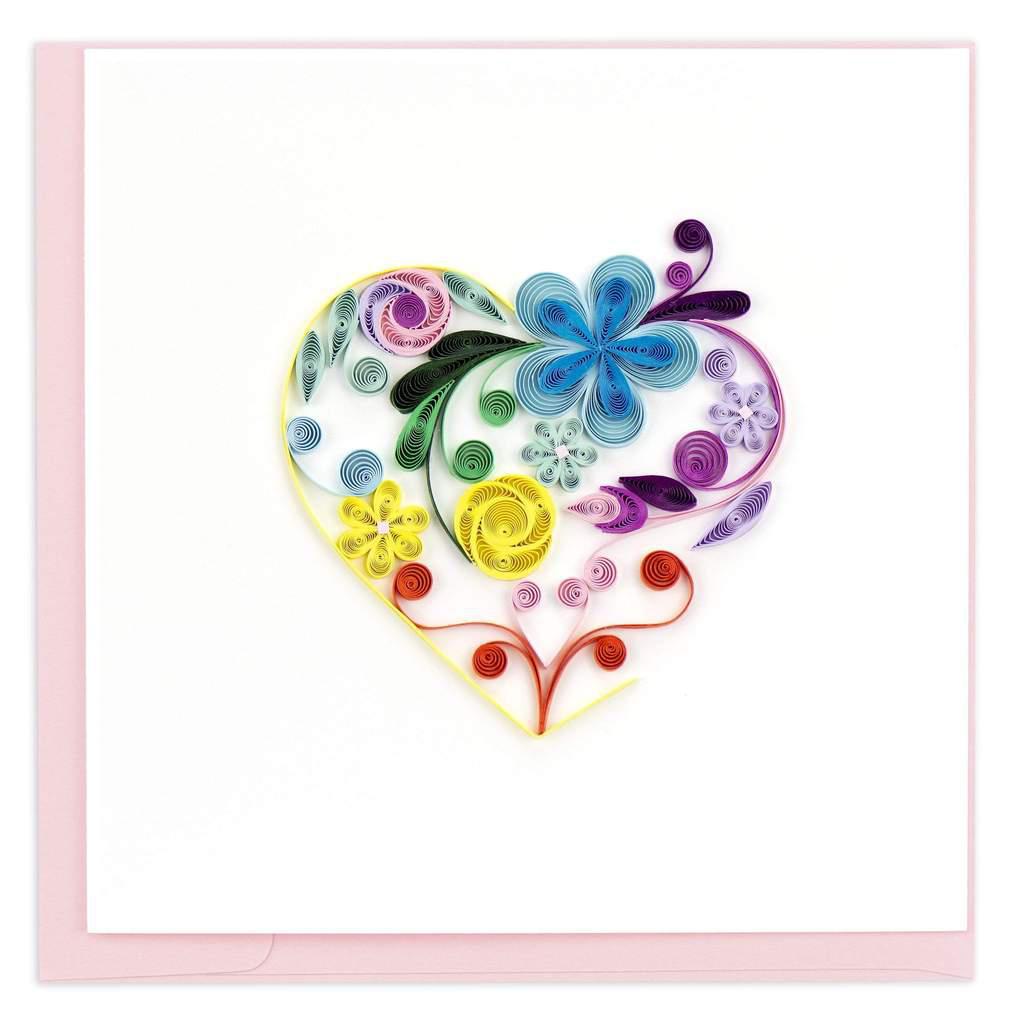 A greeting card with a handcrafted quilled paper design forming a heart shape with floral elements in multiple colors.
