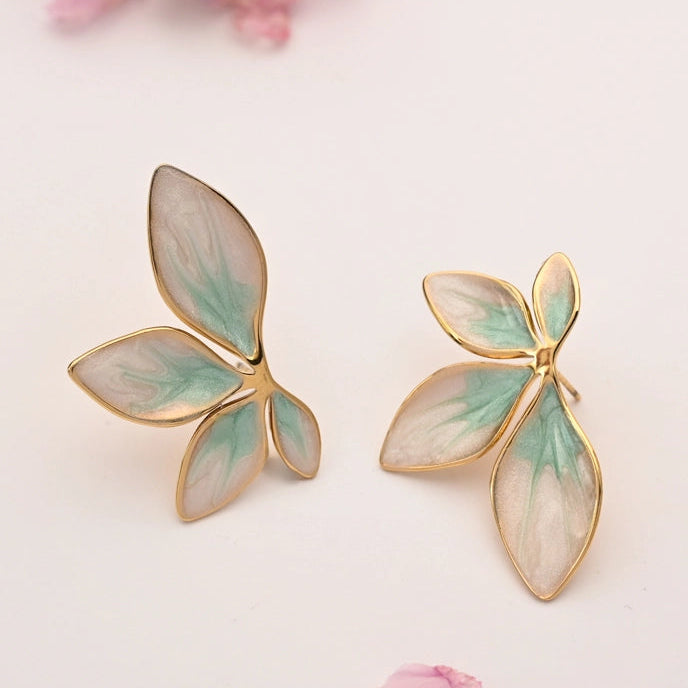 Pair of butterfly-shaped earrings with gold and green details on a light background.